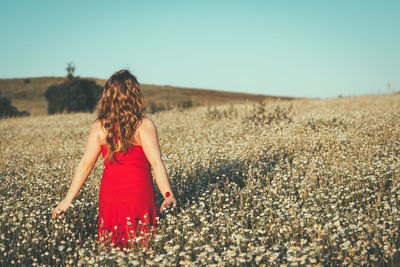 Woman standing on field against clear sky