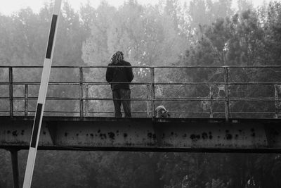 Rear view of man standing on bridge