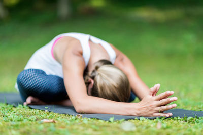 Midsection of woman lying on grass