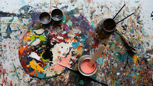 High angle view of messy paints on table