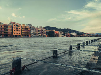 Scenic view of sea by buildings against sky
