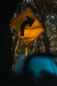 Close-up of road sign against trees