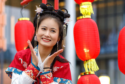 Portrait of young woman holding red bell