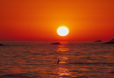 Scenic view of sea against orange sky