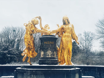 Low angle view of statue against sky during winter