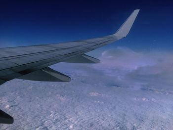 Airplane wing against blue sky