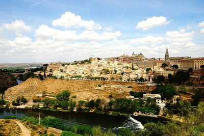 View of townscape by river against sky