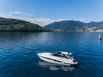 Boat moored on lake against sky