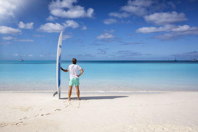 Full length of woman standing at beach against sky