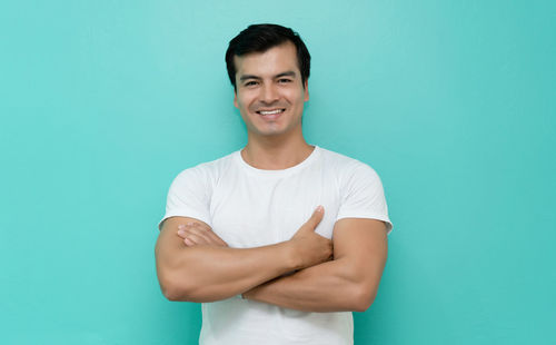 Portrait of young man against blue background