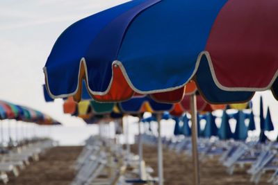 Multi colored umbrellas on beach against blue sky