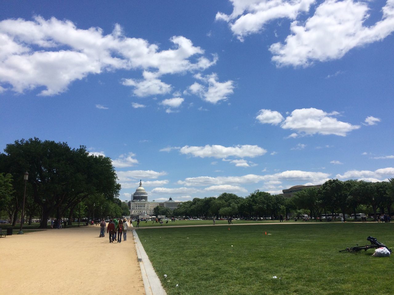 sky, men, grass, lifestyles, tree, walking, person, leisure activity, the way forward, cloud - sky, transportation, cloud, rear view, full length, road, green color, footpath, building exterior