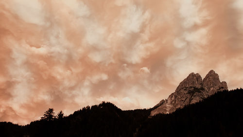 Scenic view of silhouette mountains against dramatic sky