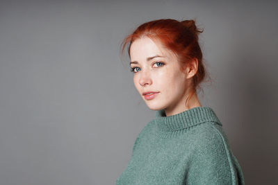 Young woman standing against wall