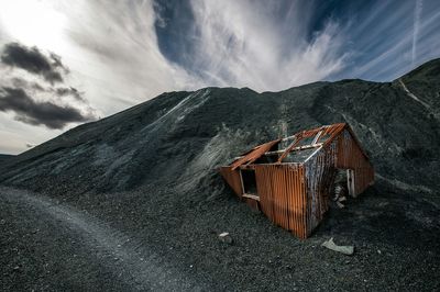 Abandoned hut on mountain against sky