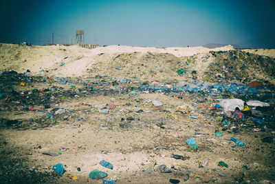 Garbage on sand at beach against sky