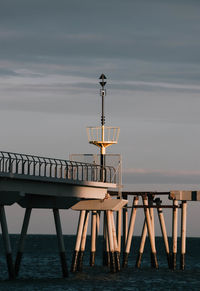Pier by sea against sky during sunset