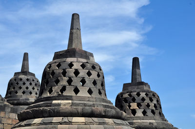 Low angle view of stupas against blue sky