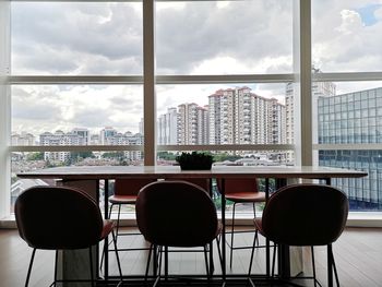 Empty chairs and table against buildings in city