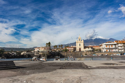 View of buildings in city against cloudy sky