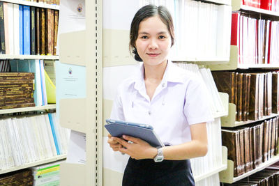 Portrait of young businesswoman standing in library