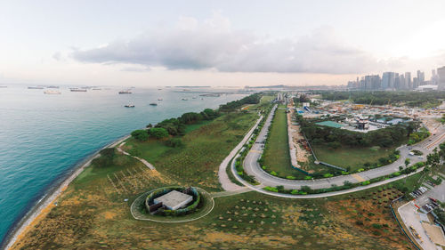 High angle view of cityscape by sea against sky