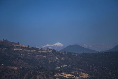 Scenic view of mountains against clear blue sky