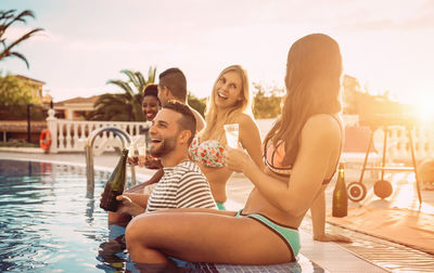 People holding drinks in swimming pool