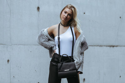 Portrait of woman standing against wall