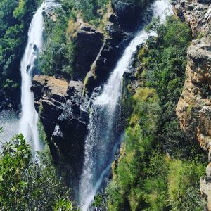 Low angle view of waterfall along rocks