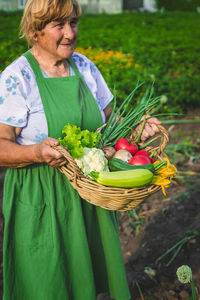 Portrait of young woman picking vegetables