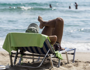 Man relaxing on lounge chair at beach