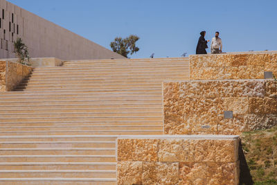 Low angle view of people on staircase against sky