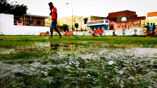 Reflection of man on puddle at lake during rainy season