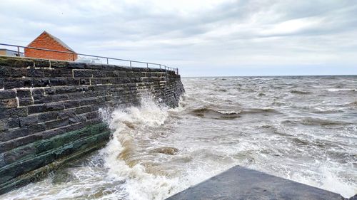 Water splashing in sea against sky