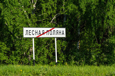 Information sign by trees in forest