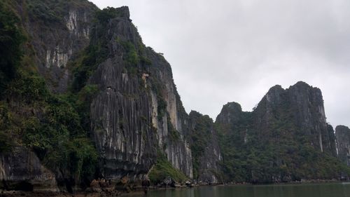 Rock formations by sea against sky