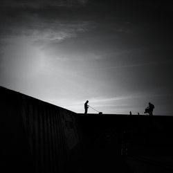 Low angle view of silhouette people against sky