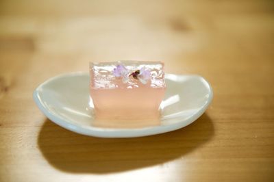 Close-up of gelatin dessert garnished with flower in plate on table