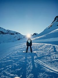 Person on snowcapped mountain against sky