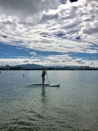 Full length of woman paddleboarding in lake