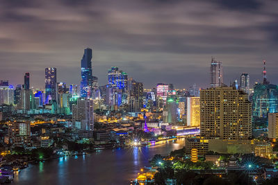 High angle view of chao phraya river amidst illuminated buildings in city