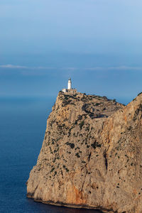 Lighthouse by sea against sky