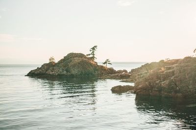 Scenic view of rocks in sea against clear sky