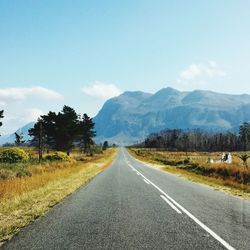 Empty road leading towards mountains