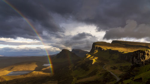 Scenic view of rainbow over mountains against sky