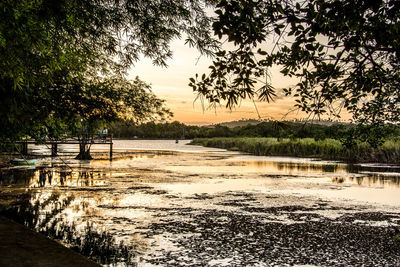 Scenic view of lake against sky at sunset