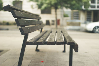 Empty bench on street in city