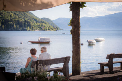 Rear view of two people overlooking calm sea