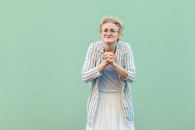 Portrait of smiling woman against blue background